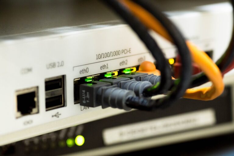 Gros plan sur un routeur réseau professionnel avec ports Ethernet actifs et câbles connectés, LED vertes indiquant un fonctionnement optimal